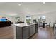 Open-concept kitchen with light gray cabinets, stainless appliances, and a large island open to the dining and living area at 3952 Almond Brook Blvd, Land O Lakes, FL 34638