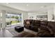 Spacious living room with sliding glass doors leading to the patio and view of the kitchen at 3952 Almond Brook Blvd, Land O Lakes, FL 34638