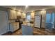 Charming kitchen featuring granite countertops, modern appliances, and white cabinets at 39772 Meadowood Loop, Zephyrhills, FL 33542