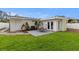 A fenced backyard features a patio with an outdoor dining set and well maintained grass at 4709 W Fair Oaks Ave, Tampa, FL 33611