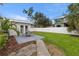 Lush backyard features an outdoor patio with a dining set and green grass lawn at 4709 W Fair Oaks Ave, Tampa, FL 33611