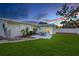Landscaped backyard includes a patio with table and chairs and a well-maintained lawn at 4709 W Fair Oaks Ave, Tampa, FL 33611