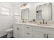 This bathroom features double sinks with framed mirrors and white cabinets at 4709 W Fair Oaks Ave, Tampa, FL 33611