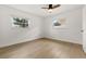 Empty bedroom with light wood floors, two windows and white walls at 4709 W Fair Oaks Ave, Tampa, FL 33611