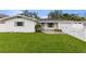 Inviting single-story home showcasing a lush lawn and a bright blue door at 4709 W Fair Oaks Ave, Tampa, FL 33611
