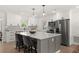 Bright kitchen features white cabinets, stainless steel appliances, quartz counters and a gray island with seating at 4709 W Fair Oaks Ave, Tampa, FL 33611