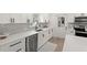 Bright kitchen featuring stainless steel appliances, gray backsplash and white cabinets at 4709 W Fair Oaks Ave, Tampa, FL 33611