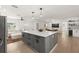 Open-concept kitchen with a gray island and quartz countertop, connecting to the living and dining areas at 4709 W Fair Oaks Ave, Tampa, FL 33611