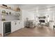 Open living room featuring a wine cooler, shiplap wall, fireplace and wood floors at 4709 W Fair Oaks Ave, Tampa, FL 33611