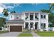 Stunning two-story home featuring a stone facade, covered entry, and upper level balconies, and an attached garage at 481 Bosphorous Ave, Tampa, FL 33606