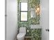 Charming powder room featuring vibrant wallpaper and a unique pendant light fixture at 500 38Th Ne Ave, St Petersburg, FL 33704