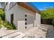 Exterior shot with a modern garage door, stone landscaping, and a balcony above the garage at 500 38Th Ne Ave, St Petersburg, FL 33704