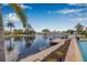Scenic waterfront view showcasing a private dock, boat lift, landscaping, and tranquil canal at 5208 Denver Ne St, St Petersburg, FL 33703