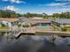 Waterfront home featuring a pool, lush landscaping, and a private dock on the canal at 5208 Denver Ne St, St Petersburg, FL 33703