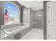 A luxurious bathroom offers a tub under a window and an enclosed glass shower at 5405 El Cerro Dr, New Port Richey, FL 34655