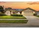 Charming single-story home with a well-maintained lawn, solar panels and a two-car garage at sunset at 5405 El Cerro Dr, New Port Richey, FL 34655