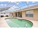 Backyard view of a screened-in pool with a seating area, perfect for outdoor relaxation at 5405 El Cerro Dr, New Port Richey, FL 34655