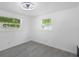 Clean bedroom with light grey floors, two windows and a ceiling fan at 5413 15Th Ave S, Gulfport, FL 33707