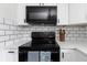 Updated kitchen with white cabinets, modern appliances, subway tile backsplash, and black accents at 5413 15Th Ave S, Gulfport, FL 33707