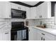 Modern kitchen features white cabinets, black appliances, and subway tile backsplash at 5413 15Th Ave S, Gulfport, FL 33707