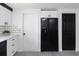Galley kitchen features white cabinets, subway tile backsplash, black appliances, and grey laminate flooring at 5413 15Th Ave S, Gulfport, FL 33707