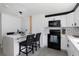 Bright modern kitchen featuring a waterfall countertop breakfast bar and black appliances at 5413 15Th Ave S, Gulfport, FL 33707