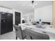 Open concept, eat-in kitchen features modern black appliances, white cabinets, seating for four, and contemporary lighting at 5413 15Th Ave S, Gulfport, FL 33707
