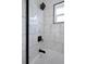 Sleek bathroom shower featuring marble-look tile, matte black fixtures, and a clear glass door at 5413 15Th Ave S, Gulfport, FL 33707