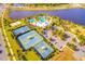 Aerial view of a community recreation area featuring a pool, tennis courts, beach volleyball, and parking at 5492 Summer Sunset Dr, Apollo Beach, FL 33572