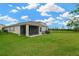 Back exterior view of the home, featuring a manicured lawn and a screened in porch at 5492 Summer Sunset Dr, Apollo Beach, FL 33572