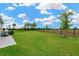 Expansive backyard features lush green grass and a sleek black fence, perfect for outdoor activities at 5492 Summer Sunset Dr, Apollo Beach, FL 33572