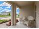 Covered front porch with two rocking chairs offers a cozy outdoor space with a view of the quiet street at 5492 Summer Sunset Dr, Apollo Beach, FL 33572
