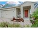 Cozy front porch featuring a comfortable wicker chair and attractive landscaping, perfect for relaxing outdoors at 5492 Summer Sunset Dr, Apollo Beach, FL 33572