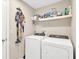 This laundry room features a washer, dryer and a shelf for supplies at 5492 Summer Sunset Dr, Apollo Beach, FL 33572