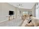A comfortably furnished living room provides access to backyard through sliding glass door, neutral paint, and ceiling fan at 5492 Summer Sunset Dr, Apollo Beach, FL 33572