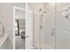 Modern bathroom featuring a glass-enclosed shower and a glimpse into the Primary bedroom at 5492 Summer Sunset Dr, Apollo Beach, FL 33572