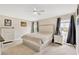 Serene bedroom features a plush bed with tufted headboard, soft carpet, and natural light from a bright window at 5492 Summer Sunset Dr, Apollo Beach, FL 33572