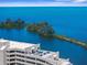 Stunning aerial view showcases the building rooftop lounge area, turquoise patio furniture, and serene ocean bay backdrop at 5915 Sea Ranch Dr # 202, Hudson, FL 34667