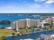 Aerial view of a waterfront building with tennis courts and parking at 5915 Sea Ranch Dr # 202, Hudson, FL 34667