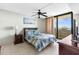 This bedroom offers a ceiling fan, a comfortable bed, and a balcony with a view at 5915 Sea Ranch Dr # 202, Hudson, FL 34667