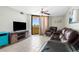 Bright living room with comfortable furniture, balcony access, and a ceiling fan for added comfort at 5915 Sea Ranch Dr # 202, Hudson, FL 34667