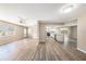 Open concept living space with wood-look floors, ceiling fan, and a view of the modern kitchen at 6241 Ansley St, Spring Hill, FL 34606