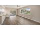 Bright living room featuring hardwood floors, a large window, and sliding glass door access at 6241 Ansley St, Spring Hill, FL 34606