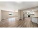 Open-concept living space featuring wood-look floors, ceiling fan, and view into the modern kitchen at 6241 Ansley St, Spring Hill, FL 34606