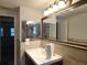 Well-lit bathroom featuring a large mirror, tiled walls, and a clean, white sink and vanity at 6317 Buster Dr, Tampa, FL 33619