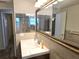 A renovated bathroom with new vanity, stylish mirror, and tiled walls, providing a modern and clean look at 6317 Buster Dr, Tampa, FL 33619