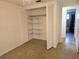 A room features an open closet, showing shelving inside, with a peek into an adjacent bathroom at 6317 Buster Dr, Tampa, FL 33619
