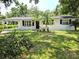 Charming single-story home featuring a well-maintained lawn, mature trees, and a welcoming exterior at 6317 Buster Dr, Tampa, FL 33619