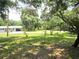 A beautifully shaded front yard with mature trees and lush green grass leading to a cozy home at 6317 Buster Dr, Tampa, FL 33619
