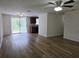 Open living room with wood floors, updated ceiling fan, and sliding glass doors to the backyard at 6317 Buster Dr, Tampa, FL 33619